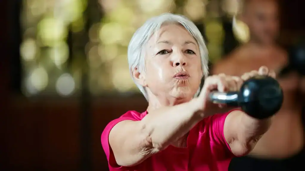 Toning Arms After 60: Empowering Womens Fitness Through Effective Weight Training 1 Older woman doing weight training Eastbourne to help her strength and longevity