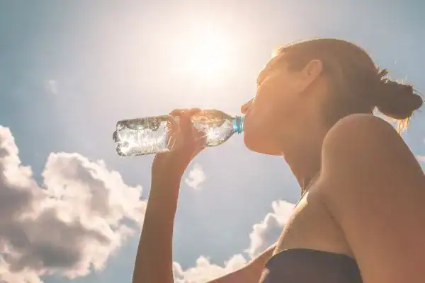 Hydration: The Secret Ingredient for a Toned Stomach and Enhanced Fitness 3 Image of woman drinking water to hydrate Eastbourne after run.